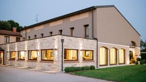 A building with a stone facade and multiple windows, likely a hotel or guesthouse.