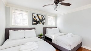 A bedroom with two beds, a ceiling fan, and artwork on the wall. - Light & Airy Family Home (Atlanta)
