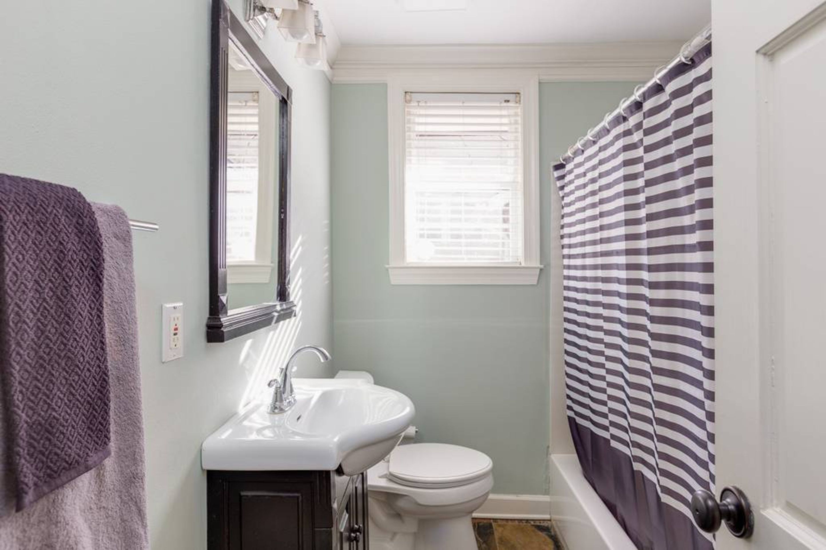 Une salle de bain avec un lavabo blanc, des toilettes et un rideau de douche.