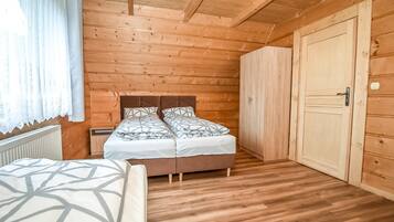 A wooden-paneled room with a bed, a wardrobe, and a radiator.