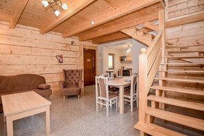 A wooden interior with a dining area, a sofa, and a chair. - Domki u Wilka (Poronin)