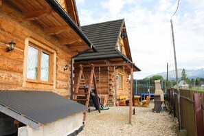 A wooden cabin with a porch, a ladder, and a grill area. - Domki u Wilka (Poronin)