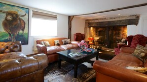 Una sala de estar acogedora con sofás de cuero, una chimenea y un cuadro de un toro.