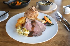A plate of roast beef with Yorkshire pudding, carrots, and gravy. - Eckington Manor (Pershore)