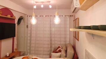 A compact kitchen with a curved island, pendant lighting, and a dining area.