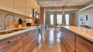 Una cocina moderna con armarios de madera, electrodomésticos de acero inoxidable y una isla central.