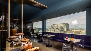 Un restaurant offrant une vue sur un bâtiment historique, où une variété de desserts et de pâtisseries sont présentés.