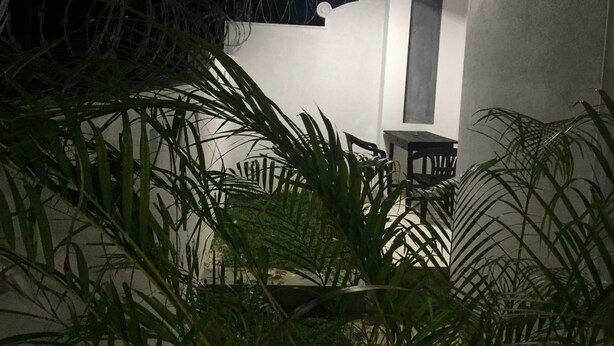 A patio area with a table and chairs, surrounded by lush green plants. - Casa 44 - Karapitiya (Galle)