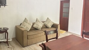 A living room with a sofa, a wooden table, and a television. - Casa 44 - Karapitiya (Galle)