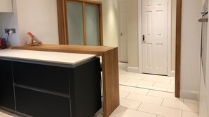 Una cocina moderna con encimera de madera y armarios negros.