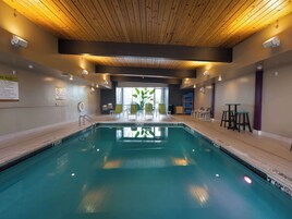 Una piscina techada, sillones reclinables de piscina