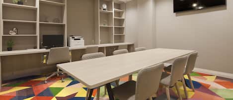 A conference room with a long table, chairs, a TV on the wall, and shelves with various items.