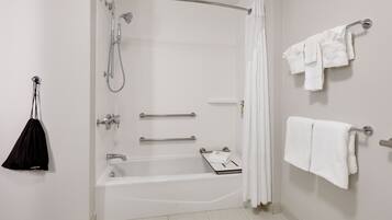 A modern bathroom with a walk-in shower, a bathtub, and a towel rack.