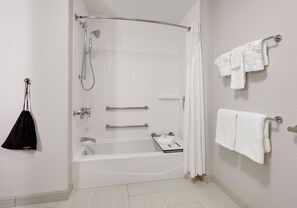 A modern bathroom with a walk-in shower, a bathtub, and a towel rack.