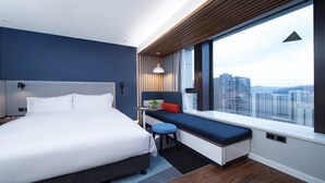 A modern hotel room with a large bed, a small desk, and a window offering a city view. - Holiday Inn Express Zhoushan Dinghai by IHG (Zhoushan)