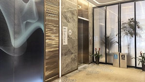 A modern elevator interior with a marble wall and a digital directory sign. - Holiday Inn Express Zhoushan Dinghai by IHG (Zhoushan)