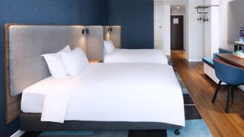 Una habitación de hotel moderna con dos camas, un escritorio y una silla.