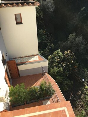 A residential building with a tiled roof, a small window, and a balcony with a railing. - Casa d'Amare (Sorrento)