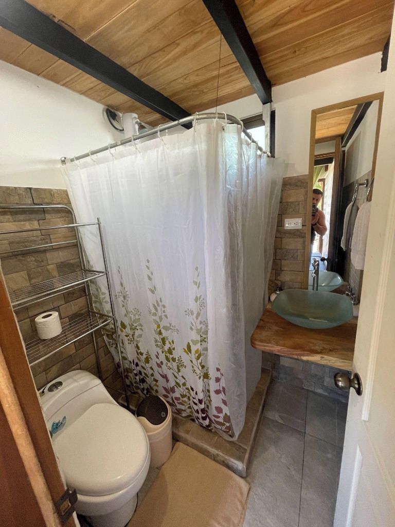Un baño pequeño con inodoro, lavabo y cortina de ducha.