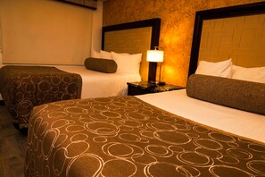 A hotel room with two beds, a nightstand with a lamp, and a brick-patterned headboard. - Vacation Rentals María Bonita (Ciudad Juárez)