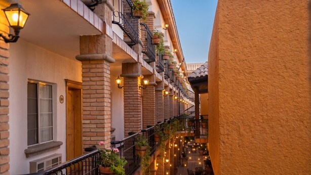 Un bâtiment doté de nombreux balcons, d’un espace extérieur aménagé pour s’asseoir et de guirlandes lumineuses.