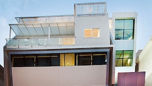 A modern building with a flat roof, large windows, and a sign reading "Downtown." - Raj Residency (Bengaluru)