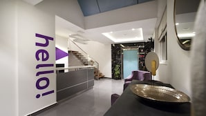 A modern interior with a staircase, a reception desk, and a seating area. - Raj Residency (Bengaluru)