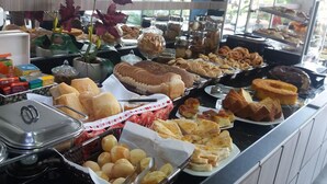A buffet with various food items including bread, pastries, and desserts. - Vitor Hotel II (Chapadão do Céu)