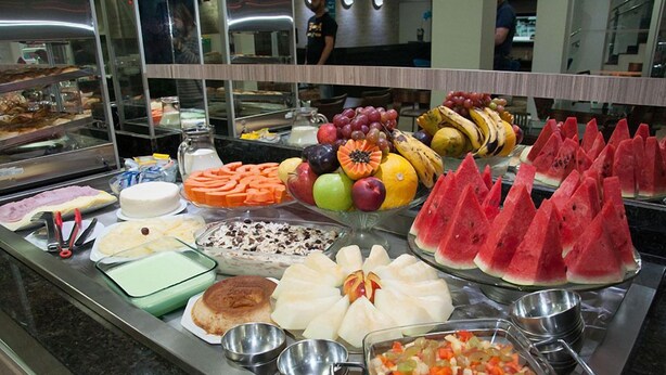 A buffet with various food items including fruits, vegetables, and desserts. - Vitor Hotel II (Chapadão do Céu)