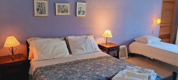 A bedroom with two beds, a nightstand with a lamp, and a bedside table with a lamp. There are three framed pictures on the wall. - Chalé na Montanha (Cunha)