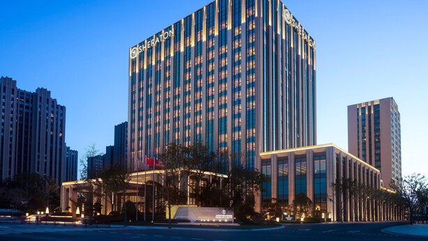 A high-rise hotel with a modern design, featuring a prominent entrance and multiple floors. - Sheraton Shanghai Fengxian (Shanghai)