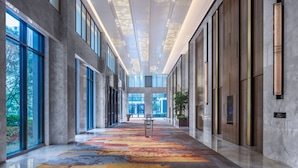 A spacious corridor with a colorful carpet, large windows, and a modern ceiling design. - Sheraton Shanghai Fengxian (Shanghai)
