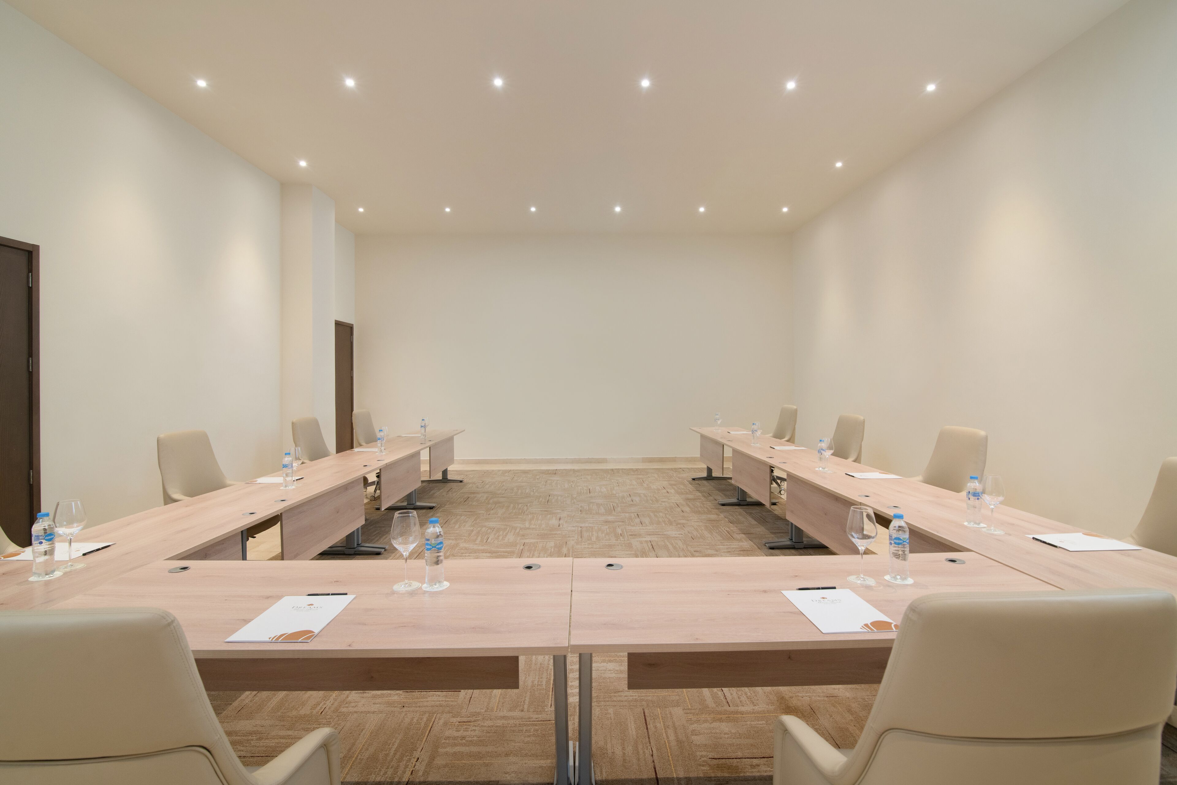 A conference room with a long table, chairs, and water bottles.