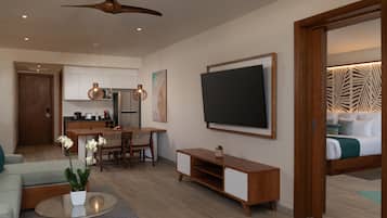 Un salon moderne doté d’un téléviseur à écran plat, de meubles en bois, d’un coin repas et d’une cuisine en arrière-plan.