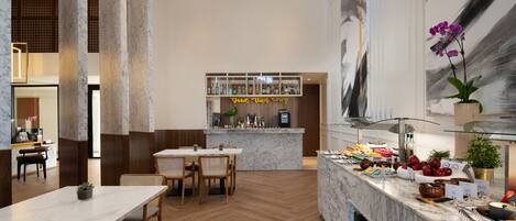 A modern restaurant with marble countertops, wooden flooring, and a central bar area.