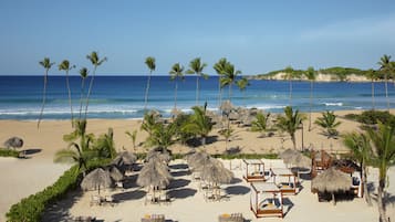 On the beach, white sand, sun loungers, beach umbrellas