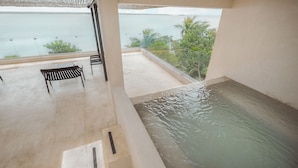 Varanda com vista para o mar, uma piscina pequena e um banco.