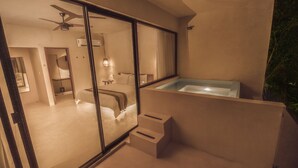 Uma casa de banho moderna com chuveiro em cabine de vidro, um espelho grande e uma banheira de hidromassagem integrada.