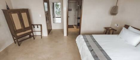 Un dormitorio con una cama grande, un armario de madera y un espejo.