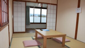 A traditional Japanese room with tatami flooring, a wooden table, and shoji screens. - ROSENCAT (Sado)