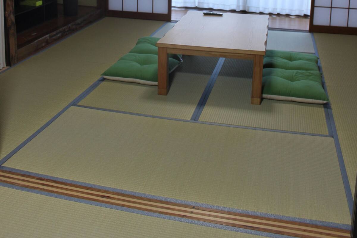 A traditional Japanese room with tatami flooring, a low wooden table, and shoji screens.