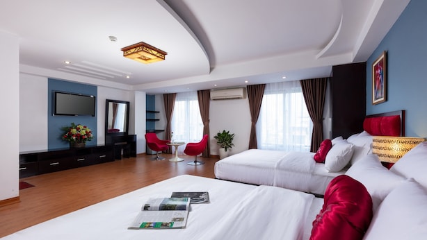 Een moderne hotelkamer met een groot bed, een bureau en een televisie.