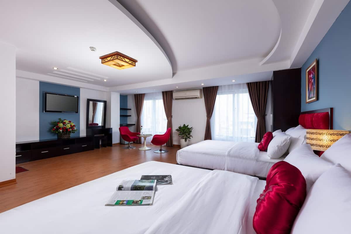 Une chambre d’hôtel moderne avec un grand lit, un bureau et une télévision.