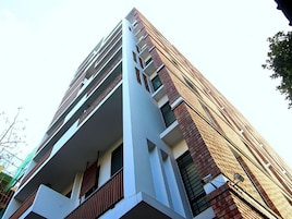 Un edificio moderno de varios pisos con balcones y una combinación de ladrillo y fachada blanca.