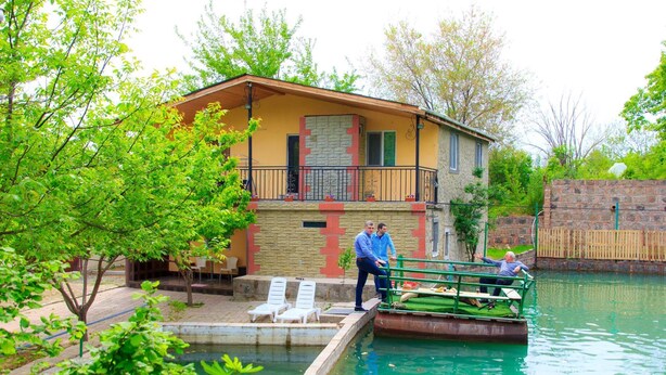 A building with a balcony, a pool, and a wooden fence. - Amiran`s Lake (Tbilisi)