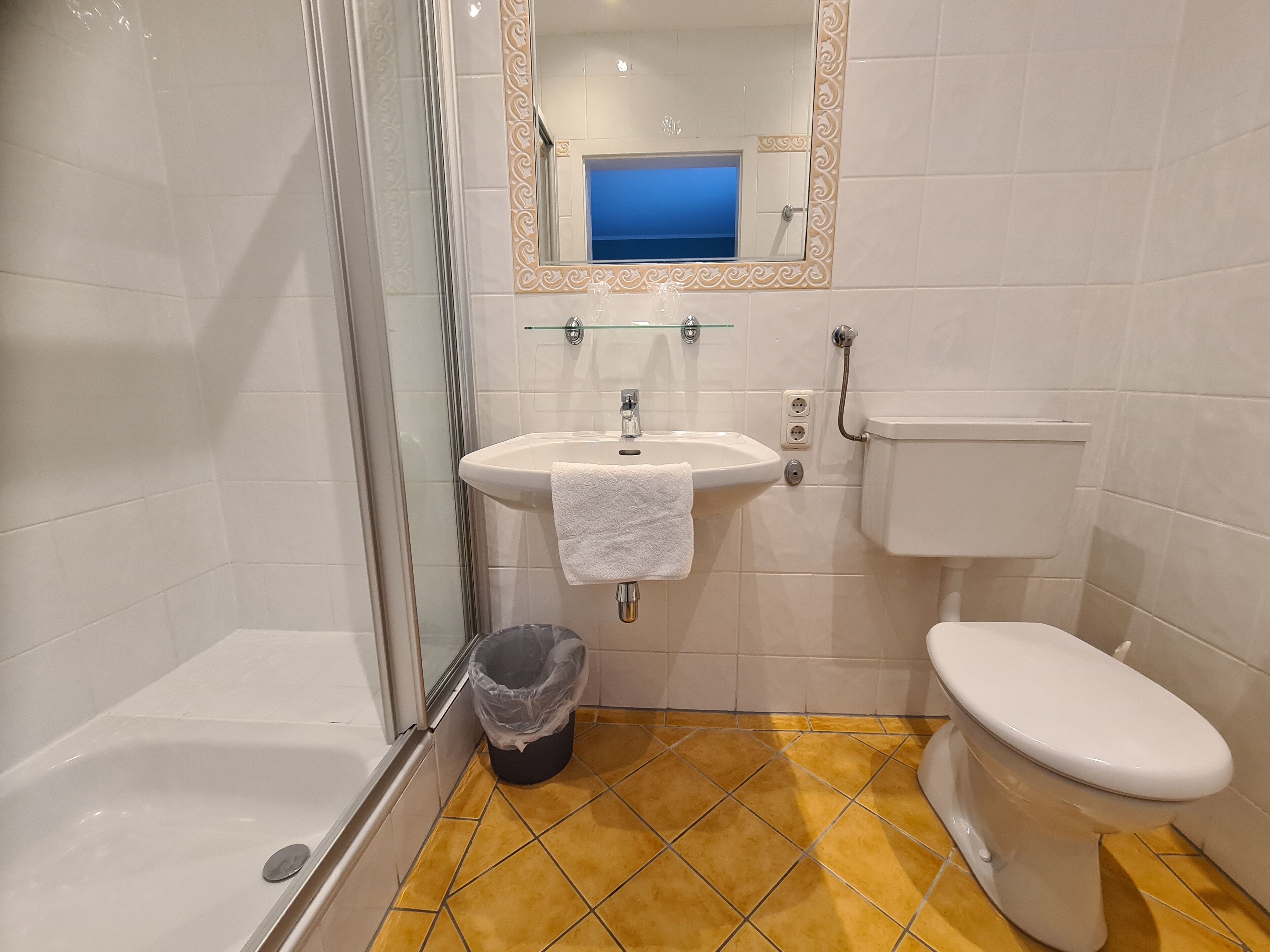 Une salle de bain équipée d’une baignoire, d’un lavabo, de toilettes et d’une douche à parois en verre.