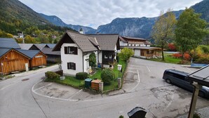 Un pueblo de montaña con casas de madera tradicionales, un estacionamiento y vistas de las montañas circundantes.