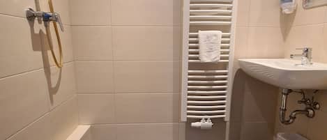 Un baño con ducha, lavabo e inodoro.