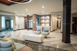 A modern lobby with a reception desk, seating area, and a refreshment bar. - Holiday Inn St. Louis - Creve Coeur by IHG (St. Louis)