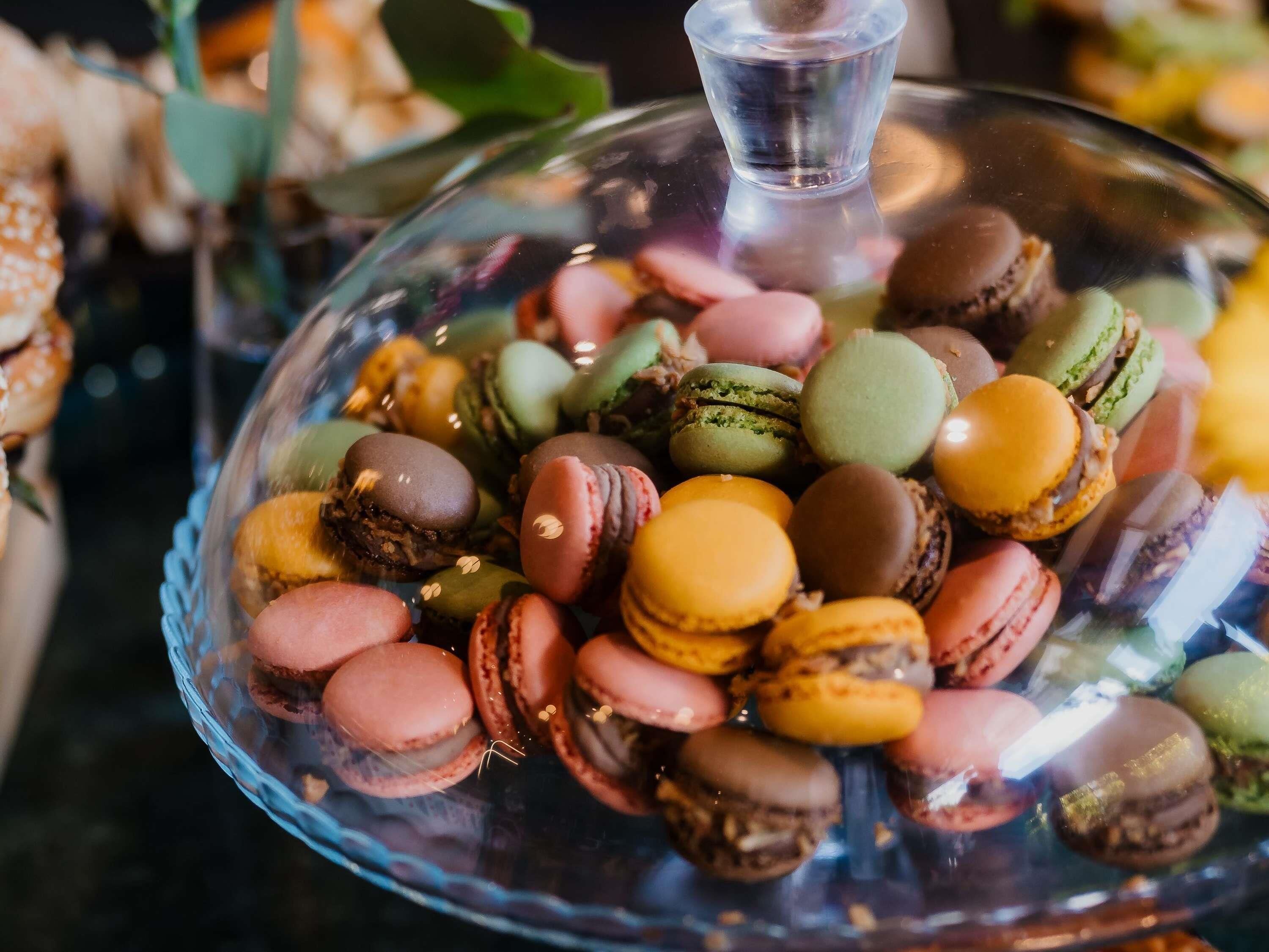 A glass dome displaying a variety of macarons.